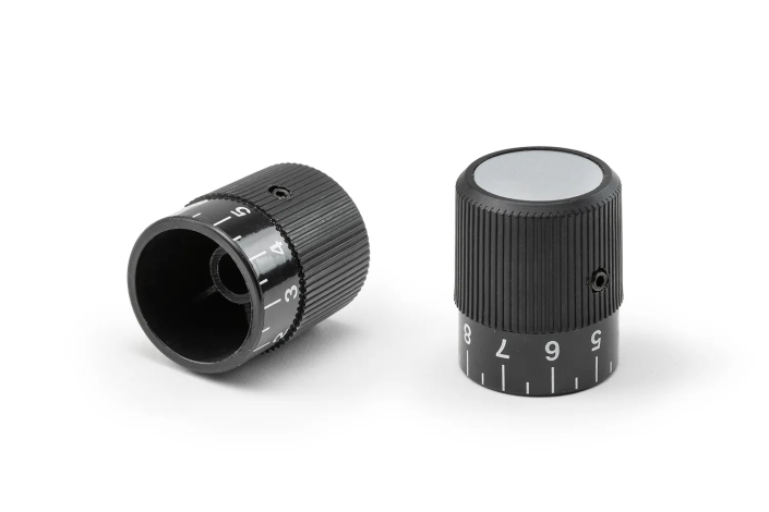Monplast-Knurled-Grip-Graduated-Scale Two black knurled grips with graduated scales arranged on a neutral background.