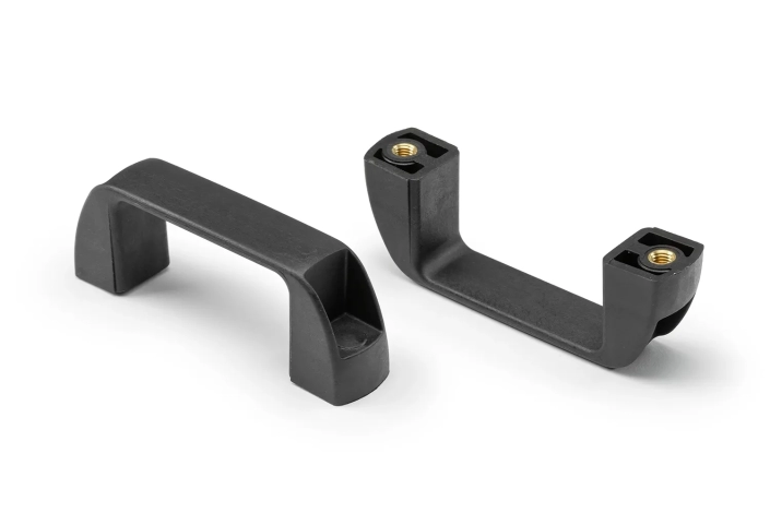 Two black plastic handles with bushing arranged on a neutral background.
