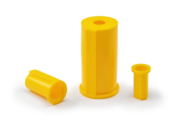 Three yellow shaft cover caps, of different sizes, arranged on a neutral background.