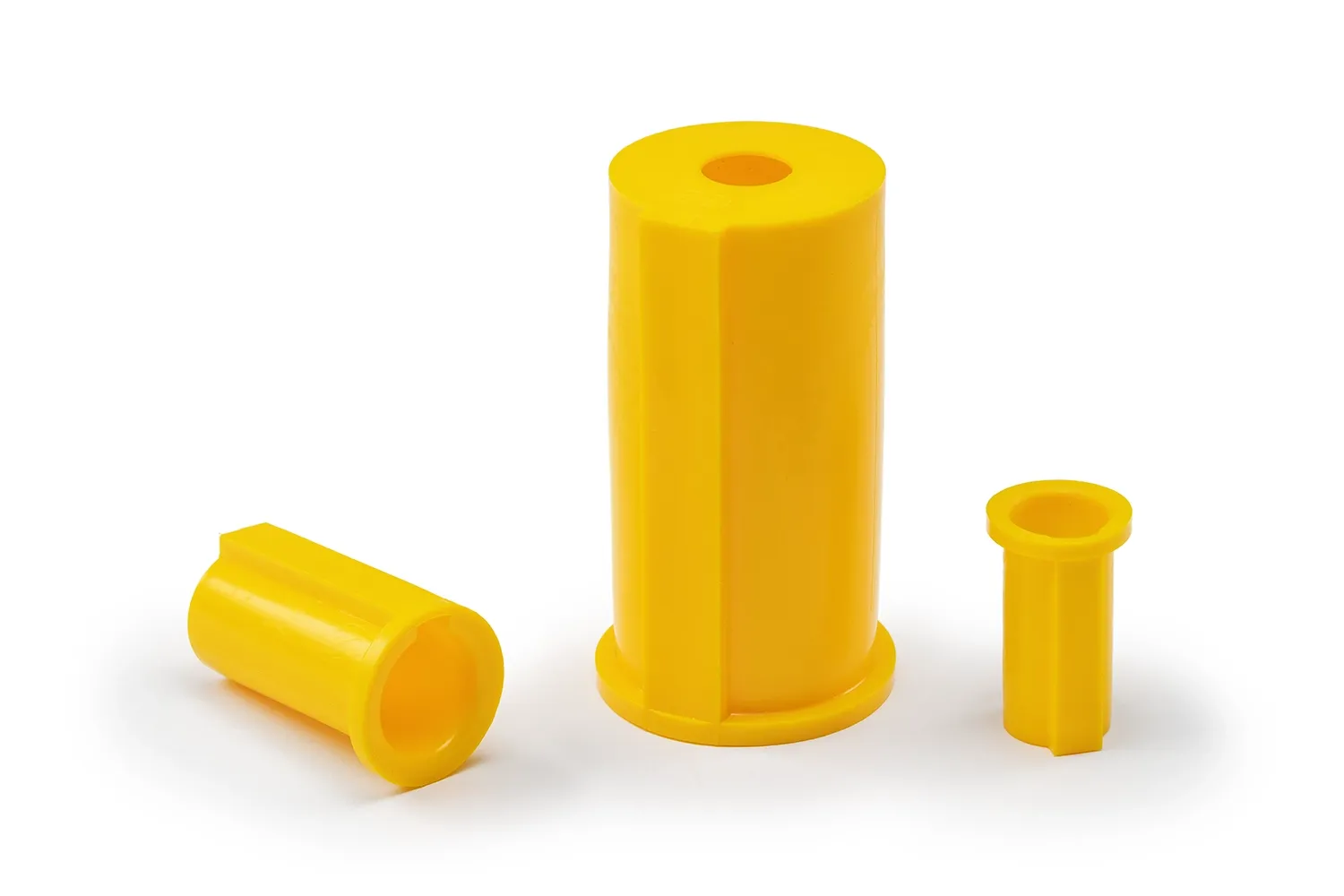Three yellow shaft cover caps, of different sizes, arranged on a neutral background.