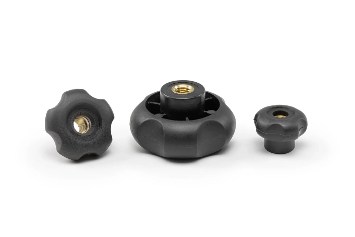 Three black 5-lobe handwheels with bushing and through hole, in different sizes, arranged on a neutral background.