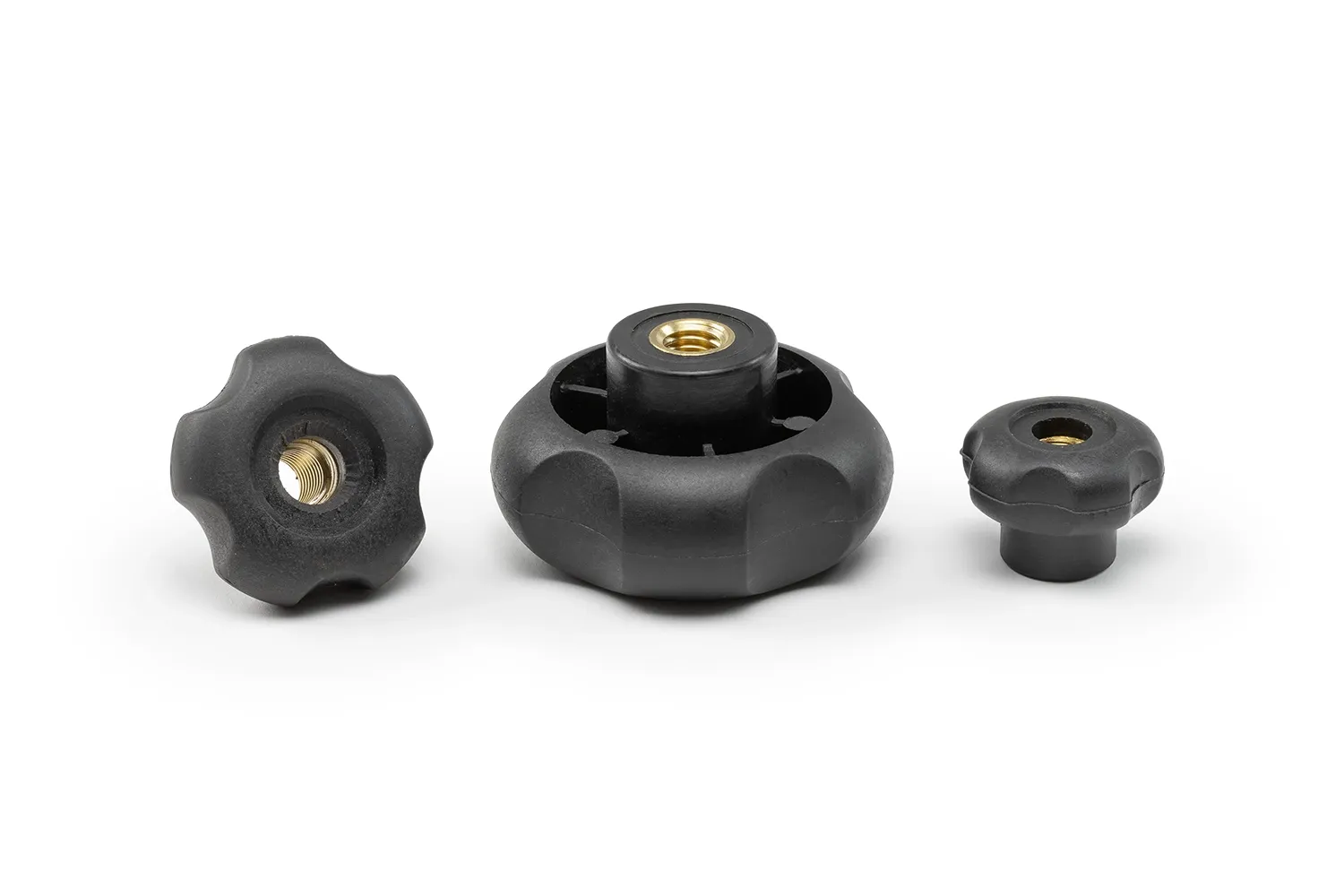 Monplast-5-Lobe-Handwheel-Through-Hole Three black 5-lobe handwheels with bushing and through hole, in different sizes, arranged on a neutral background.
