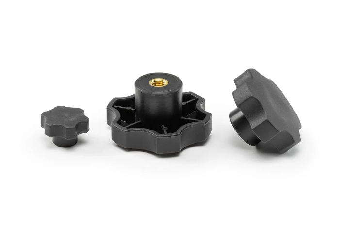 Three black 6-lobe handwheels with bushings, in different sizes, arranged on a neutral background.