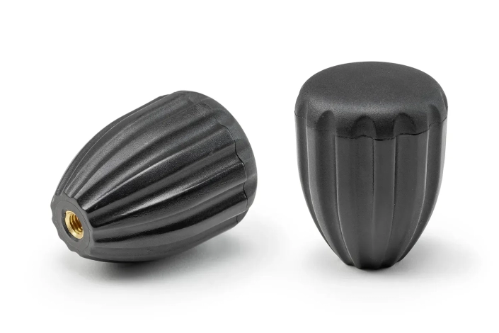 Two black oval handwheels with bushings arranged on a neutral background.