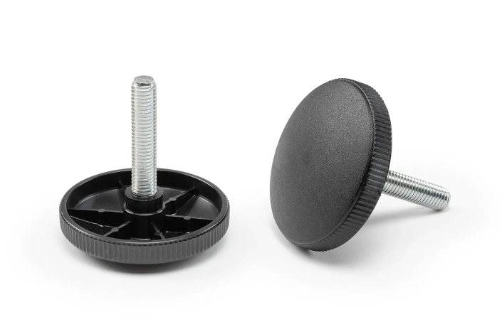 Two black knurled handwheels with pin arranged on a neutral background.